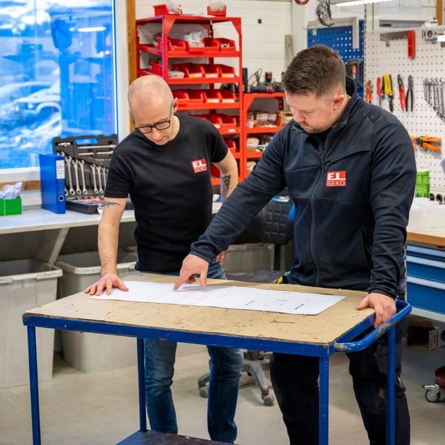 To ansatte hos Elseko AS ser på tekniske tegninger på et bord